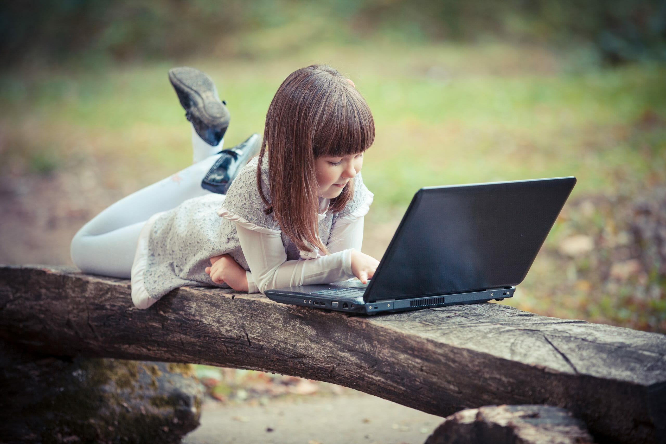 Corsi di inglese per ragazzi: nella foto una bambina con un PC portatile.